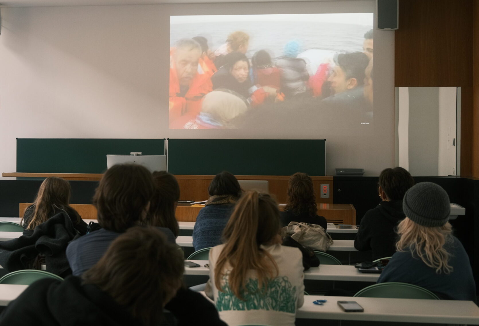 

                          Bild: Einige junge Menschen sitzen in einem Seminarraum und schauen einen Film über FLuchtrouten.

                          